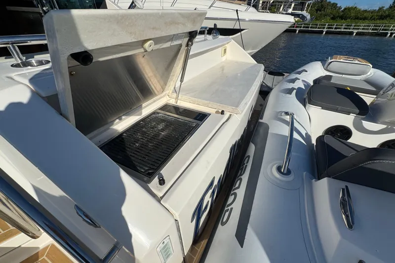  Yacht Photos Pics Outdoor grill on 2016 Tiara Yachts C44 Coupe, docked beside an inflatable boat.