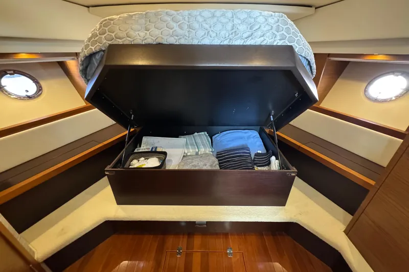  Yacht Photos Pics 2016 Tiara Yachts C44 Coupe cabin with under-bed storage, featuring neatly organized linens.
