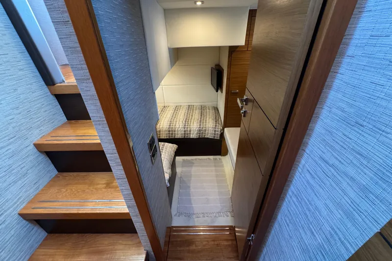  Yacht Photos Pics 2016 Tiara Yachts C44 Coupe cabin interior with wooden stairs and cozy bedding.