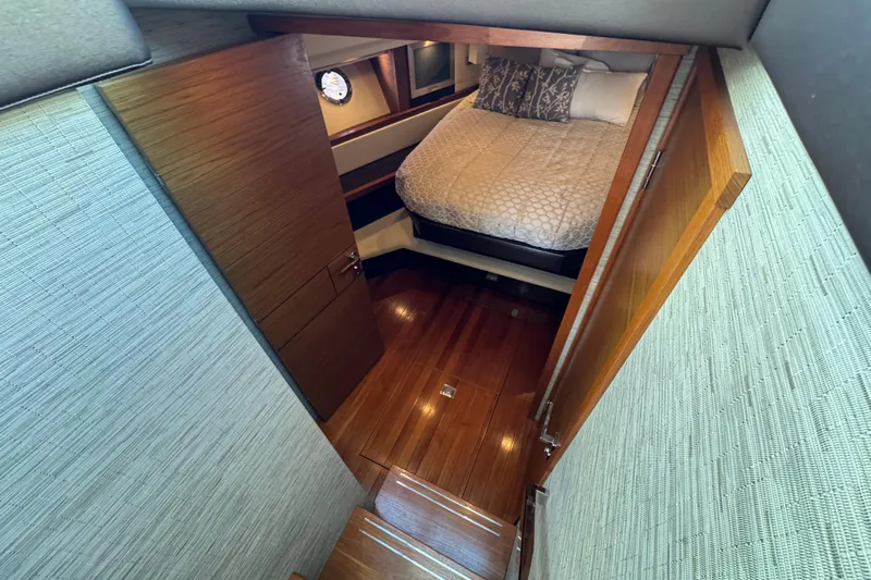  Yacht Photos Pics Interior cabin of 2016 Tiara Yachts C44 Coupe with wooden flooring and cozy bed.