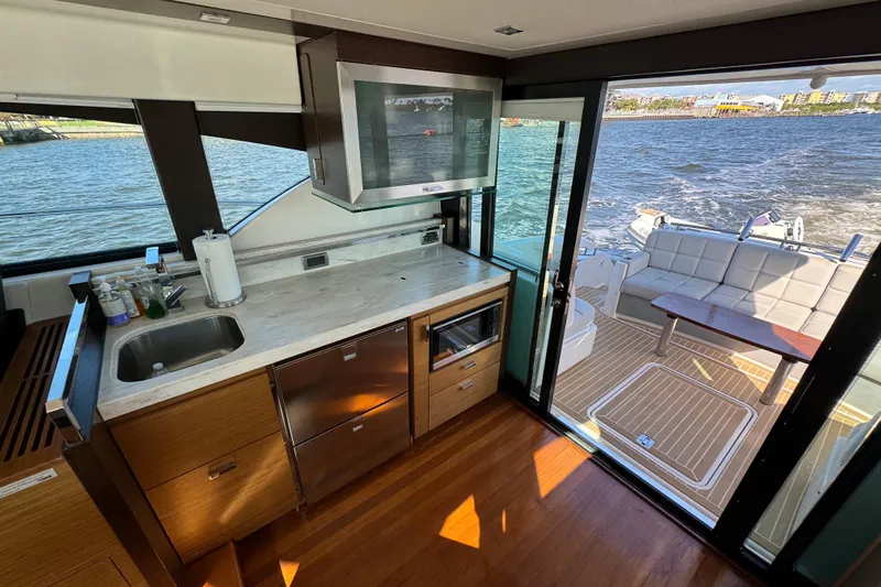  Yacht Photos Pics Interior of 2016 Tiara Yachts C44 Coupe with modern kitchen and outdoor seating area.