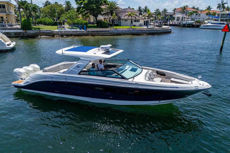  Yacht Photos Pics 2020 Sea Ray SLX 400 boat cruising on a sunny waterfront with palm trees.