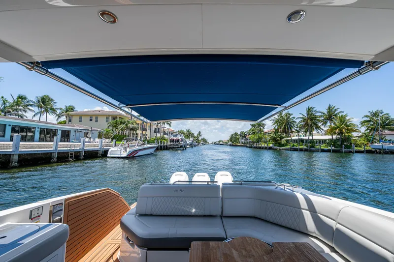  Yacht Photos Pics 2020 Sea Ray SLX 400 boat cruising on a sunny waterfront with palm trees.