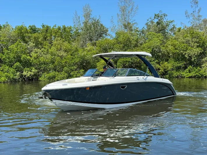  Yacht Photos Pics 2020 Cobalt R30 boat cruising on a calm river with lush greenery in the background.