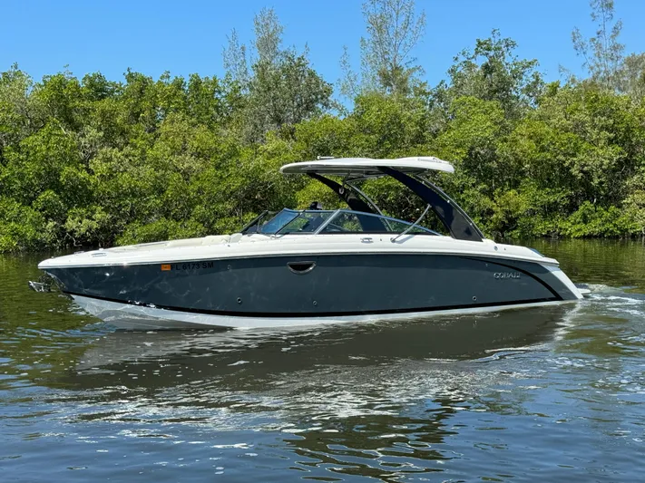  Yacht Photos Pics 2020 Cobalt R30 boat cruising on a calm river with lush greenery in the background.