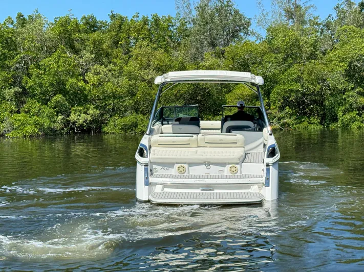  Yacht Photos Pics 2020 Cobalt R30 boat cruising on a calm river surrounded by lush greenery.