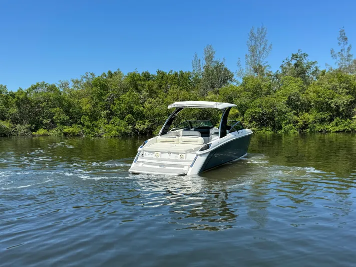  Yacht Photos Pics 2020 Cobalt R30 boat cruising on a calm river with lush greenery.