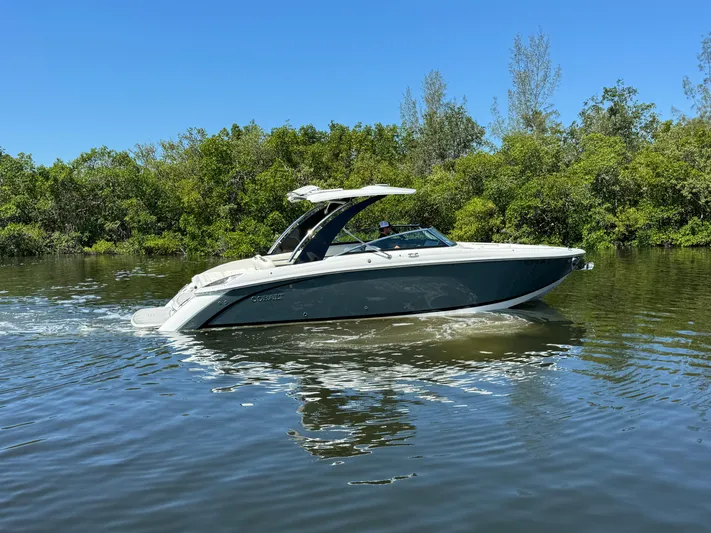  Yacht Photos Pics 2020 Cobalt R30 boat cruising on a calm river with lush greenery.