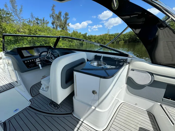  Yacht Photos Pics 2020 Cobalt R30 boat interior with helm and sink, docked on a sunny day.