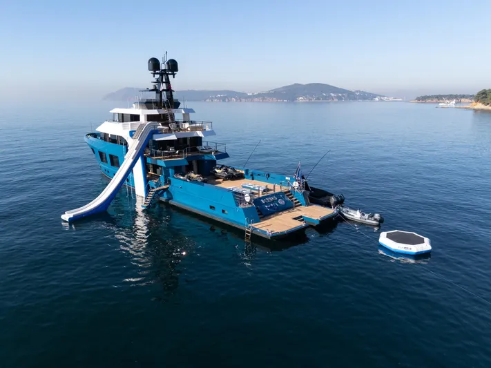 King Benji Yacht Photos Pics Luxurious 2024 Dunya Yachts model with slide and water toys in serene ocean setting.