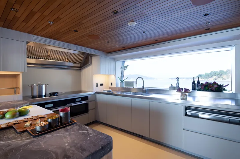 King Benji Yacht Photos Pics Modern yacht kitchen with sleek countertops, large window, and wooden ceiling, Dunya Yachts 2024 model.