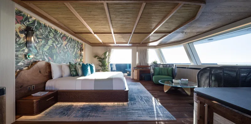 King Benji Yacht Photos Pics Luxurious Dunya Yachts 2024 interior with elegant bedroom, tropical decor, and panoramic windows.