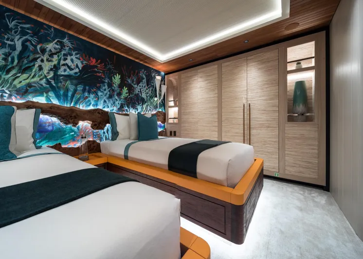 King Benji Yacht Photos Pics Luxurious 2024 Dunya Yachts bedroom with twin beds, vibrant ocean-themed decor, and modern lighting.