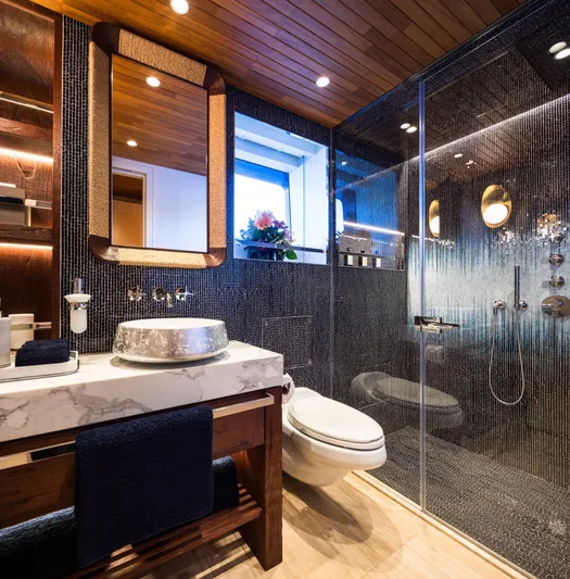 King Benji Yacht Photos Pics Luxurious yacht bathroom with modern fixtures, elegant wood accents, and a glass shower enclosure.