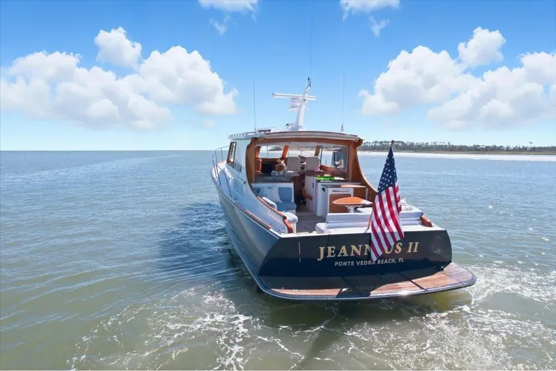 Jeannius II Yacht Photos Pics 2015 Hinckley Talaria 43 yacht on open water, American flag displayed.