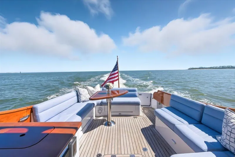 Jeannius II Yacht Photos Pics Hinckley Talaria 43 yacht, 2015 model, cruising on open water with American flag.