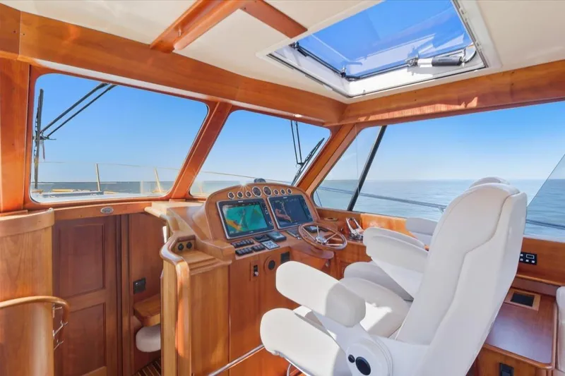 Jeannius II Yacht Photos Pics Helm of 2015 Hinckley Talaria 43 yacht with wooden interior and ocean view.