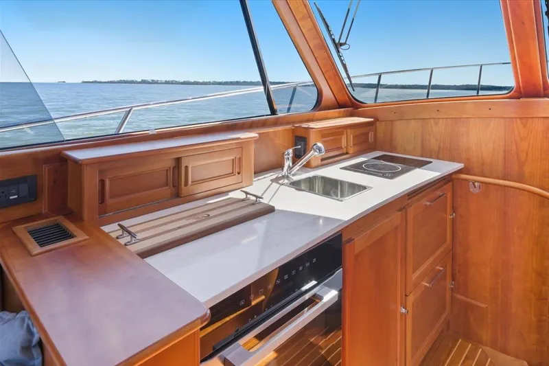 Jeannius II Yacht Photos Pics Interior of 2015 Hinckley Talaria 43 yacht with wooden cabinetry and modern kitchen amenities.