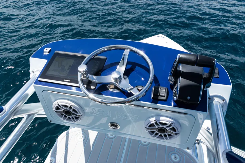  Yacht Photos Pics 2023 SeaVee 390Z boat helm with steering wheel and navigation system on open water.