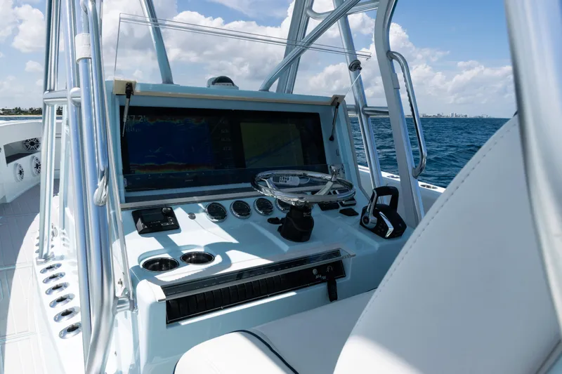  Yacht Photos Pics 2023 SeaVee 390Z boat console with steering wheel and navigation system on open water.
