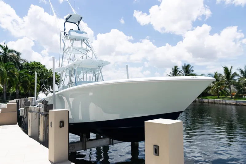  Yacht Photos Pics 2023 SeaVee 390Z boat docked by tropical waterfront under blue sky.