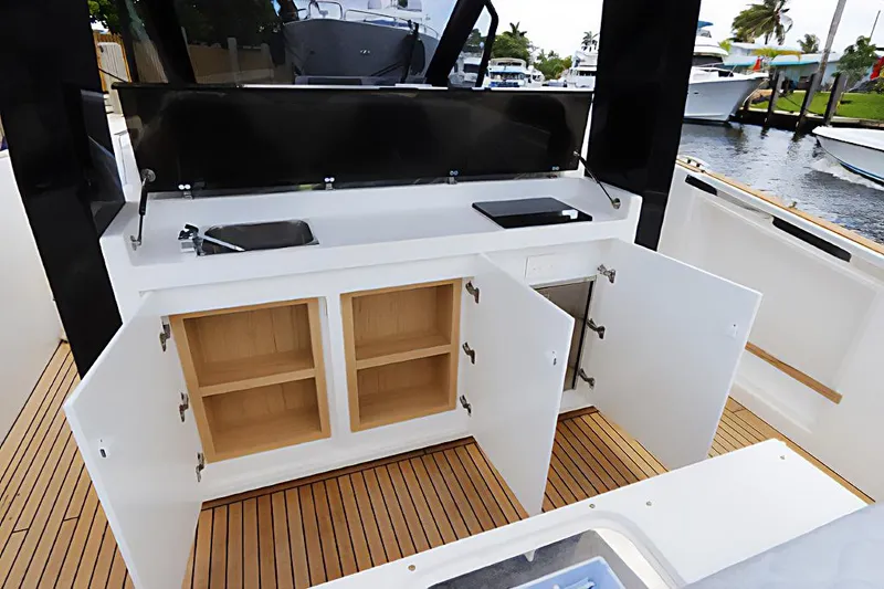  Yacht Photos Pics 2023 Astondoa 377 Coupe Outboard yacht interior with open storage cabinets.