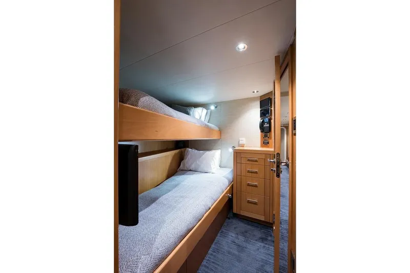 Serenity Yacht Photos Pics Cozy bunk bed cabin in 2018 Westport Raised Pilothouse yacht, featuring wooden cabinetry.