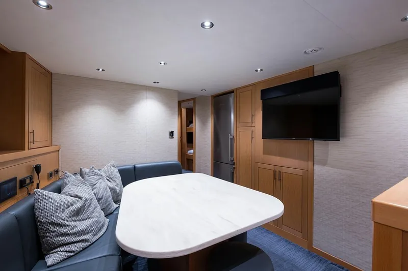 Serenity Yacht Photos Pics Luxurious interior of 2018 Westport Raised Pilothouse yacht with modern dining area and TV.