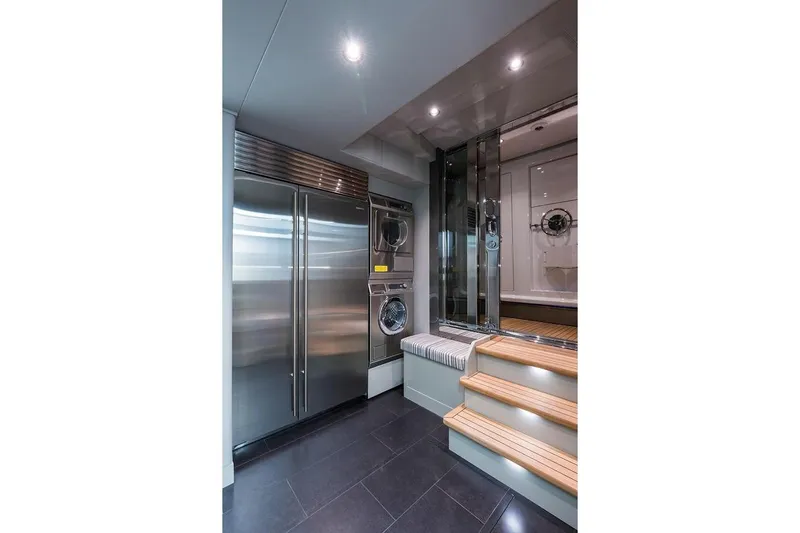 Serenity Yacht Photos Pics Laundry area in 2018 Westport Raised Pilothouse yacht with modern appliances and wooden steps.