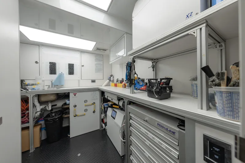 Serenity Yacht Photos Pics Workshop area inside 2018 Westport Raised Pilothouse yacht, featuring tools and storage cabinets.