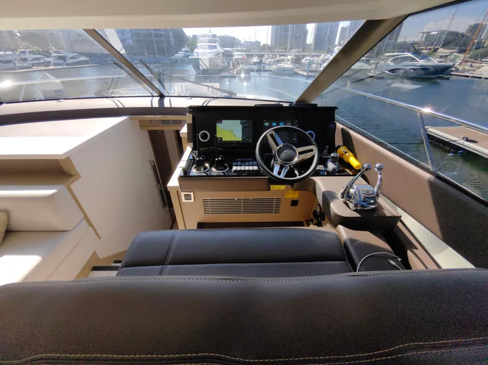  Yacht Photos Pics Luxurious 2022 Prestige 590 yacht cockpit with modern navigation controls, docked in a marina.
