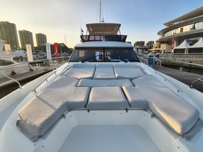  Yacht Photos Pics Luxury 2022 Prestige 590 yacht with spacious sunbathing area at marina.