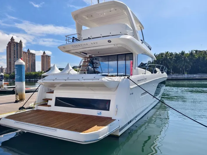  Yacht Photos Pics Luxury 2022 Prestige 590 yacht docked at marina, with scenic waterfront backdrop.