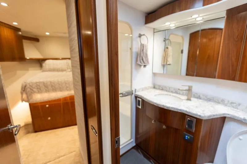 Trailer Trash Yacht Photos Pics Luxurious interior of 2021 Viking 58 Convertible yacht featuring bedroom and bathroom.