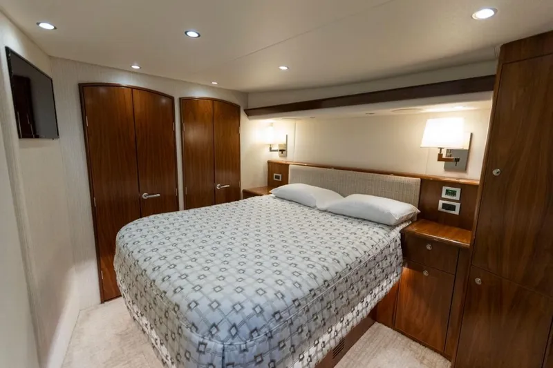 Trailer Trash Yacht Photos Pics Luxurious bedroom interior of 2021 Viking 58 Convertible yacht with elegant wood finishes.