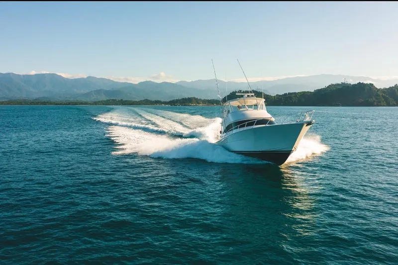 Trailer Trash Yacht Photos Pics 2021 Viking 58 Convertible yacht cruising on open water with scenic mountain backdrop.