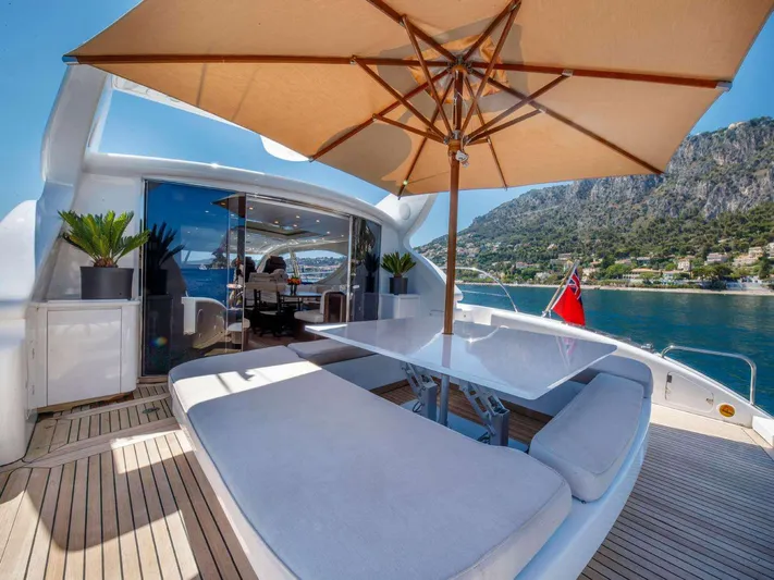 Ultim Yacht Photos Pics Luxury yacht deck with seating, umbrella, and scenic coastal view; Arno Leopard Canteri Navale Srl 2006.