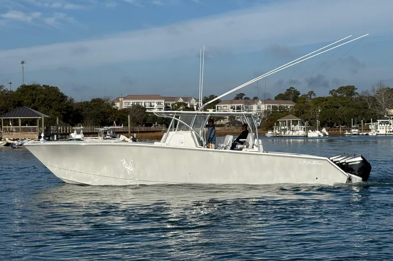 Trade In-- Bring All Offers & Trades Yacht Photos Pics 2021 SeaHunter 41 CTS boat cruising on calm water near a marina.