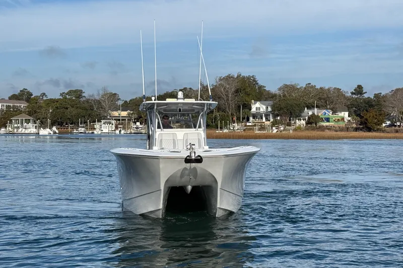 Trade In-- Bring All Offers & Trades Yacht Photos Pics 2021 SeaHunter 41 CTS boat cruising on calm waters near a coastal town.