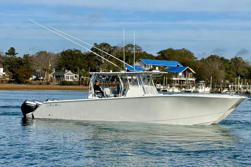 Trade In-- Bring All Offers & Trades Yacht Photos Pics 2021 SeaHunter 41 CTS boat cruising on a calm waterway with scenic background.
