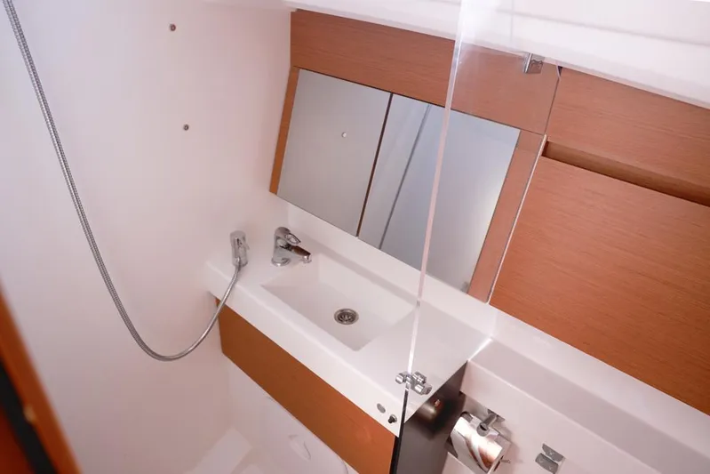 Espiritu Milagro Yacht Photos Pics Modern bathroom in 2022 Jeanneau Sun Odyssey 410 yacht with sleek fixtures and mirror.