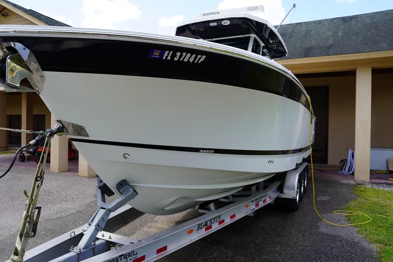  Yacht Photos Pics 2023 Blackfin 302 CC boat on trailer, parked outdoors.
