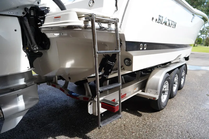  Yacht Photos Pics 2023 Blackfin 302 CC boat on trailer with ladder and outboard motor.