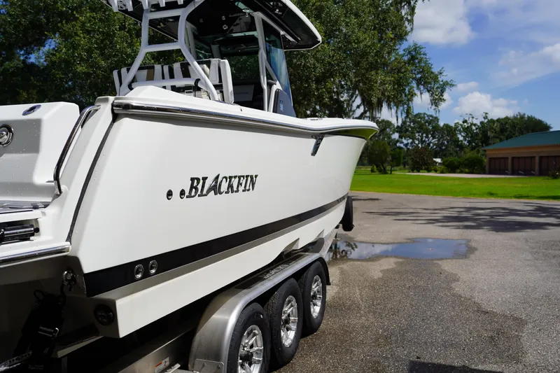  Yacht Photos Pics 2023 Blackfin 302 CC boat on trailer, parked outdoors on a sunny day.