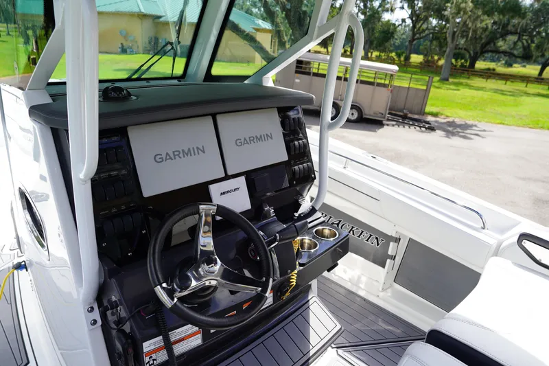 Yacht Photos Pics 2023 Blackfin 302 CC boat cockpit with Garmin displays and steering wheel.