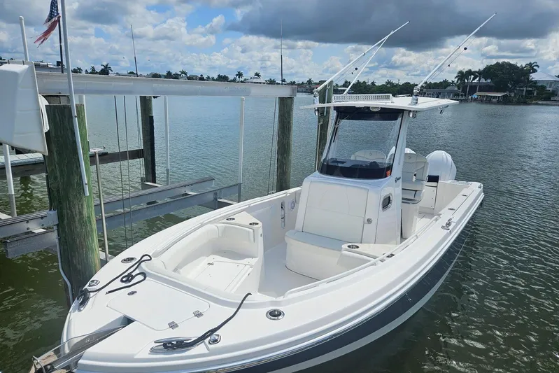  Yacht Photos Pics 2023 Edgewater 262CC boat docked on calm water under cloudy sky.