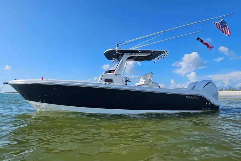  Yacht Photos Pics 2023 Edgewater 262CC boat on water, clear sky, flags waving, side view.