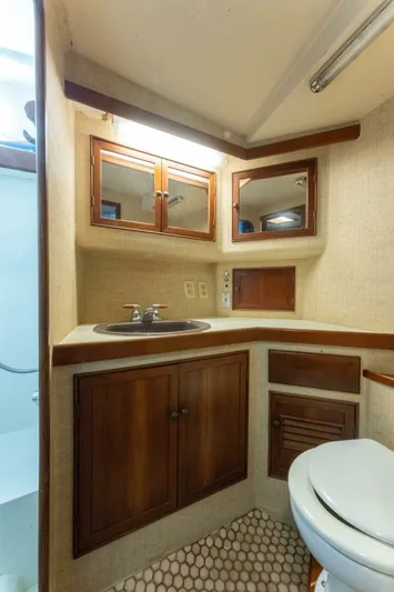 Natural Yacht Photos Pics 1984 Custom Carolina 41 Ricky Scarborough yacht bathroom with wooden cabinets and sink.