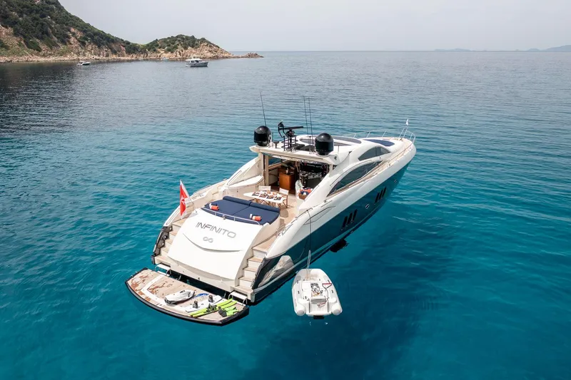 Infinito Yacht Photos Pics Luxury Sunseeker Predator 82 yacht, 2007 model, anchored in clear blue waters.