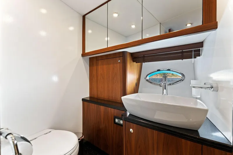 Infinito Yacht Photos Pics Luxurious bathroom in 2007 Sunseeker Predator 82 yacht with modern fixtures and wood accents.